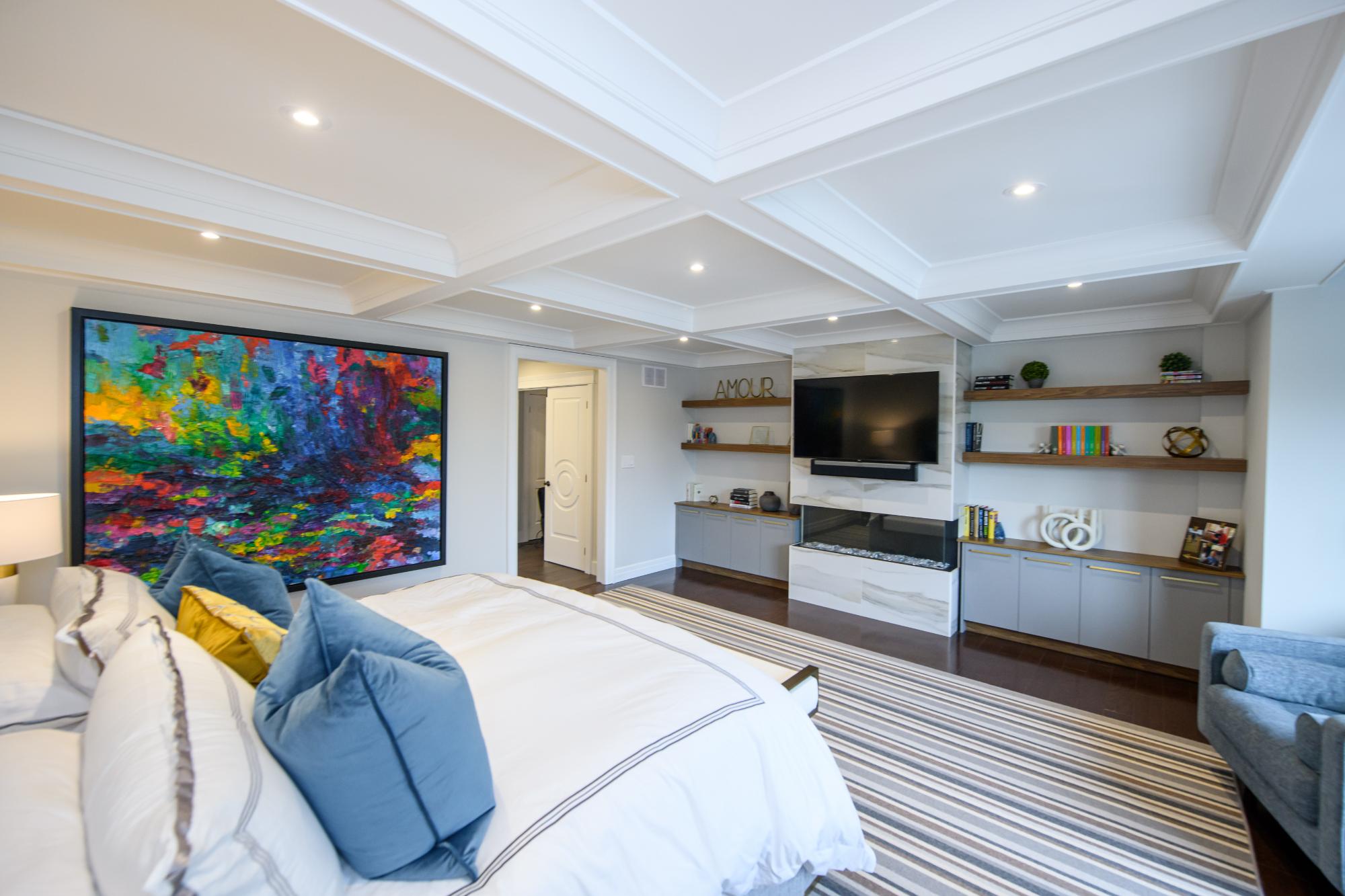 art work, fireplace, custom book shelves, tiled fireplace surround, coffered ceiling, pot lights